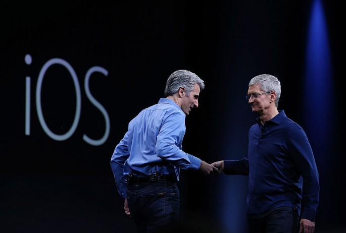 Apple Senior VP of Software Engineering Craig Federighi shakes hands with Apple CEO Tim Cook during the Apple WWDC in June 2015 in San Francisco, California.