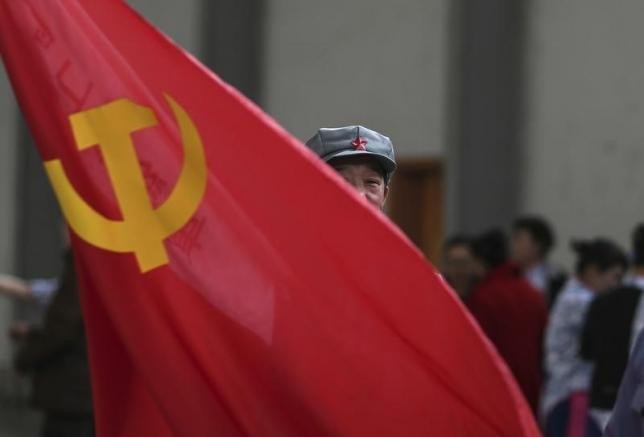 A member of China's Communist Party waves a flag during a gathering in Kunming, Yunnan Province.