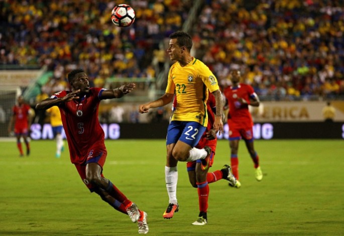 Brazil winger Philippe Coutinho (#22) competes for the ball against two Haiti defenders.