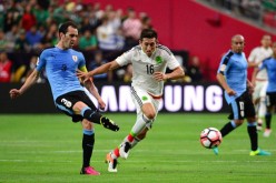 Uruguay defender Diego Godin (L) competes for the ball against Mexico's Hector Herrera.