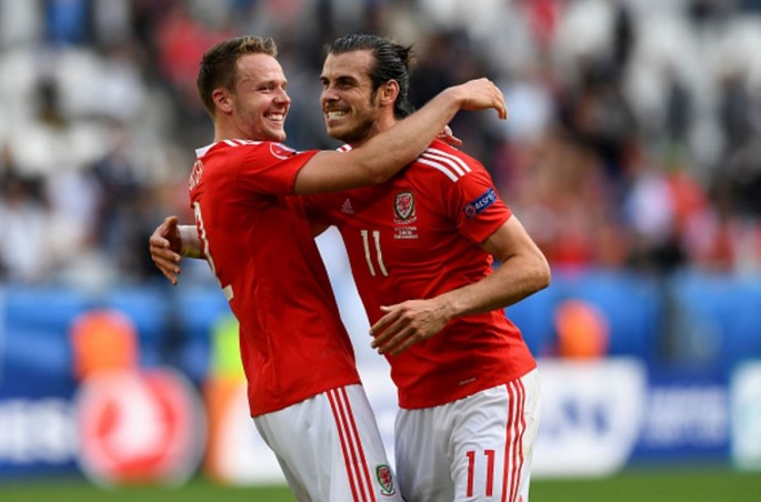Wales striker Gareth Bale (R) celebrates with teammate Chris Gunter after scoring the opening goal versus Slovakia.
