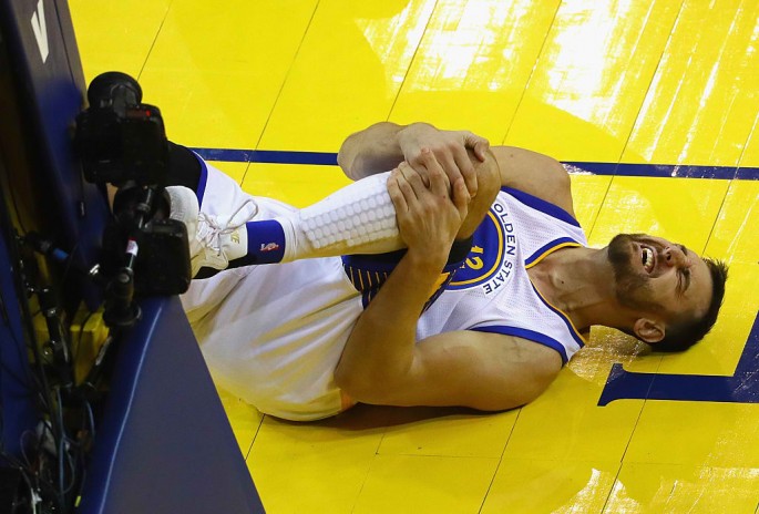 Andrew Bogut #12 of the Golden State Warriors reacts after suffering an apparent injury during the second half against the Cleveland Cavaliers in Game 5 of the 2016 NBA Finals at ORACLE Arena on June 13, 2016 in Oakland, California.