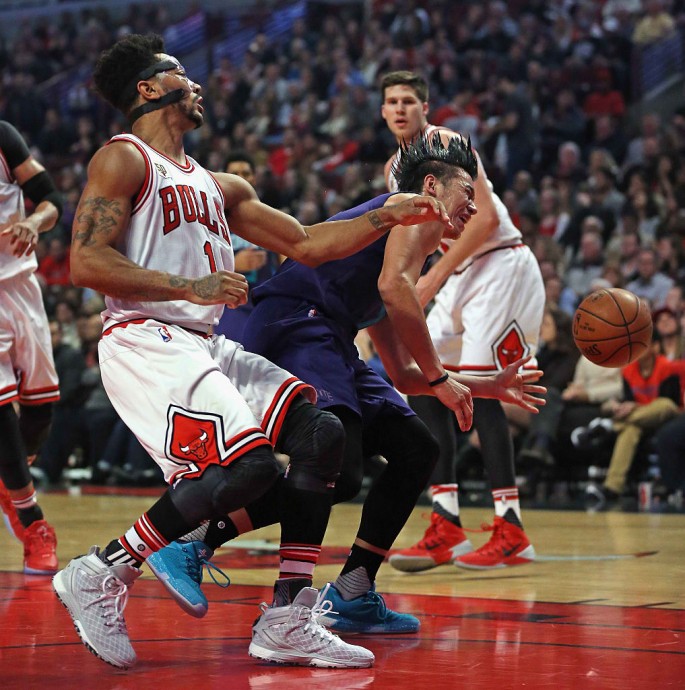 Jeremy Lin #7 of the Charlotte Hornets is fouled by Derrick Rose #1 of the Chicago Bulls at the United Center on December 5, 2015 in Chicago, Illinois.