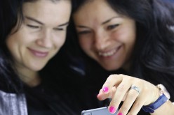 Two women look at a Huawei Honor phone