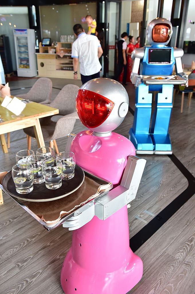 Robot waiters serve at a restaurant in Yiwu, China.