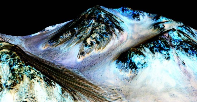 These dark, narrow, 100 meter-long streaks called recurring slope lineae flowing downhill on Mars are inferred to have been formed by contemporary flowing water.