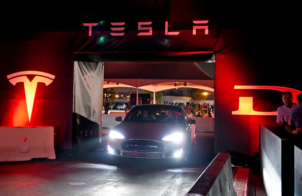 Tesla owners take a ride in the new Tesla 'D' model electric sedan after Elon Musk, CEO of Tesla, unveiled the dual engine chassis of the new Tesla 'D' model, at the Hawthorne Airport Oct.r 9, 2014 in Hawthorne, California. 