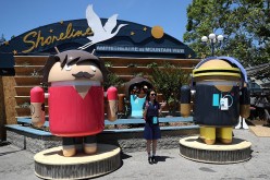 An attendee poses for a photo next to Android characters during Google I/O 2016 at Shoreline Amphitheatre on May 19, 2016 in Mountain View, California. 