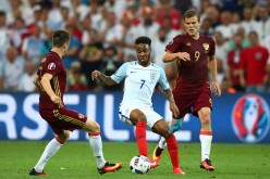England and Manchester City winger Raheem Sterling (#7) competes for the ball against two Russian defenders.