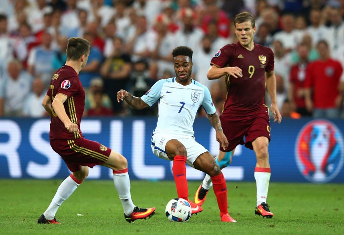 England and Manchester City winger Raheem Sterling (#7) competes for the ball against two Russian defenders.