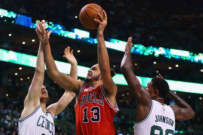 Joakim Noah #13 of the Chicago Bulls takes a shot over Kelly Olynyk #41 of the Boston Celtics and Amir Johnson #90 during the second half at TD Garden on December 9, 2015 in Boston, Massachusetts.