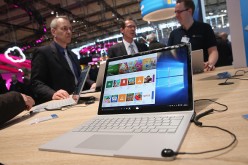 Visitors check out the Surface Book laptop at the Microsoft stand at the 2016 CeBIT digital technology trade fair on the fair's opening day on March 14, 2016 in Hanover, Germany. 