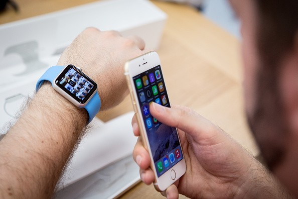 A man is checking his Apple Watch and syncing it with his iPhone at a store. 