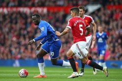 Everton striker Romelu Lukaku (L) competes for the ball against two Manchester United defenders.
