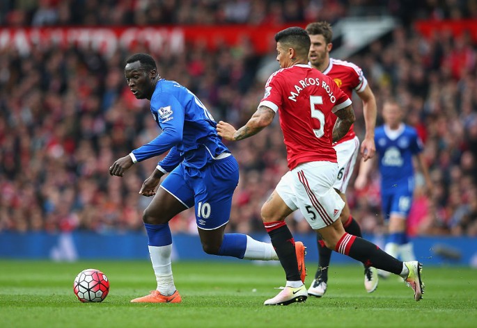 Everton striker Romelu Lukaku (L) competes for the ball against two Manchester United defenders.