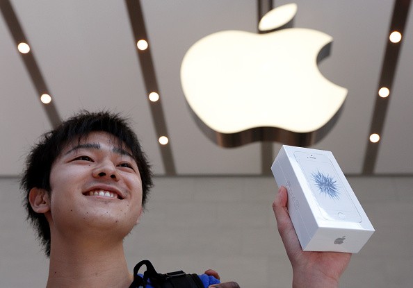A customer shows his Apple Inc. iPhone SE after purchasing it at the company's Omotesando store on March 31, 2016 in Tokyo, Japan. 