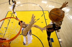 Golden State Warriors center Andrew Bogut trying to block a shot by Cleveland Cavaliers guard JR Smith
