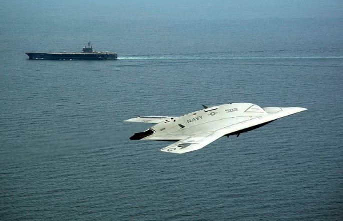 US Navy X-47B in flight alongside the USS George H.W. Bush.