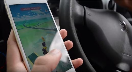 A player plays Pokemon GO in his car.