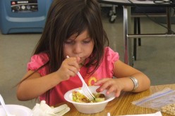 Preschool child is eating vegetables as her meal.