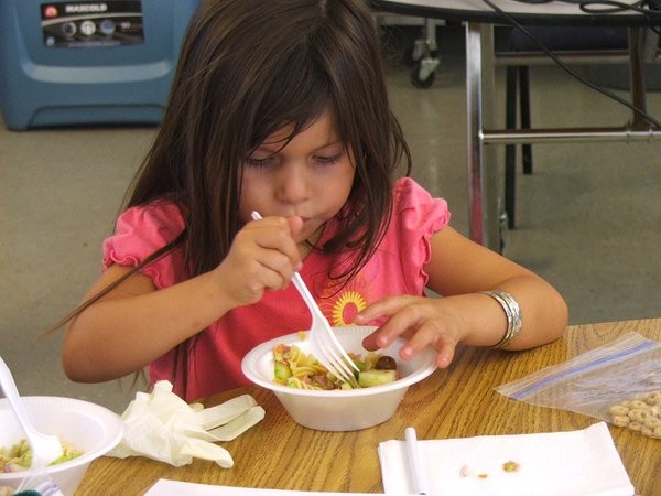 Preschool child is eating vegetables as her meal.