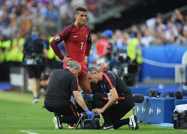 Cristiano Ronaldo receives the medical treatment on the touchline during the UEFA EURO 2016 Final match between Portugal and France at Stade de France on July 10, 2016 in Paris, France. 