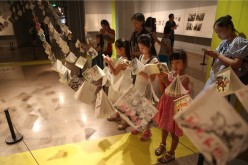 Children reading serial picture books at the exhibition.