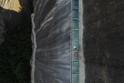 A visitor lies down on a skywalk glass bridge in central China's Hunan Province, July 8, 2016. 