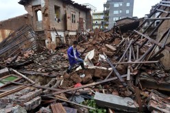A villager walks over destroyed houses in Fujiian after heavy rains and flooding caused by typhoon Nepartak.