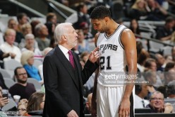 Coach Gregg Popovich talks to Tim Duncan during a Spurs home game.