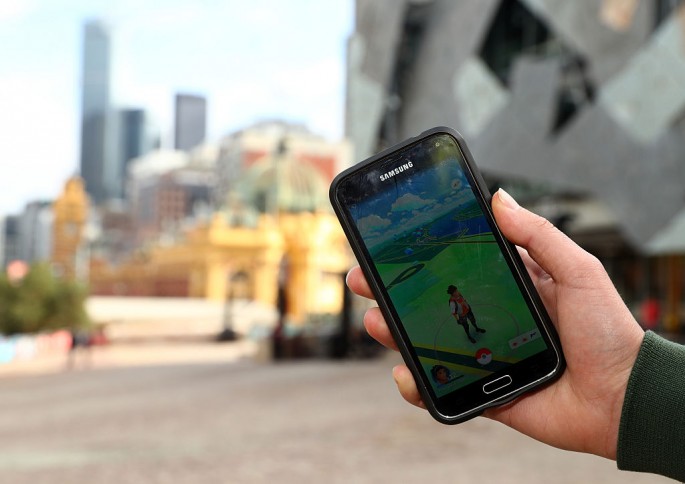 A man holds up his phone as he plays the pokemon Go game on July 13, 2016 in Melbourne, Australia. The augmented reality app requires players to look for Pokemon in their immediate surroundings with the use of GPS and internet services turning the whole w