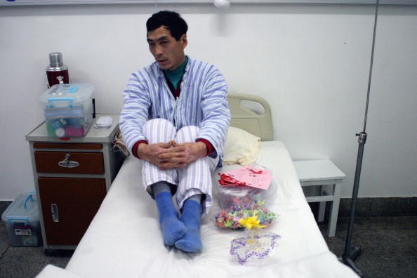 A hand-picked Aids patient receives a gift from students during a media event in Ditan hospital to demonstrate China's concern for HIV November 30, 2003 in Beijing, China. 
