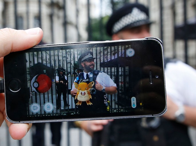 A Raticate can be seen in the foreground near the police during a gameplay of Pokemon Go.