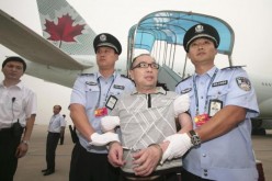 Chinese police escort a fugitive who was transported back to China from Canada.