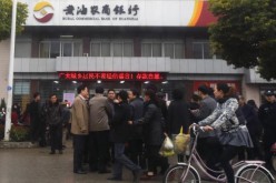 People gather outside a rural bank in Yancheng, Jiangsu Province.