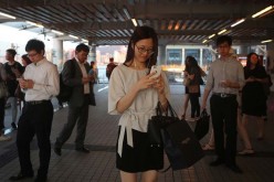 A woman plays Nintendo Co's Pokemon Go augmented-reality game on her smartphone in Hong Kong on Monday.