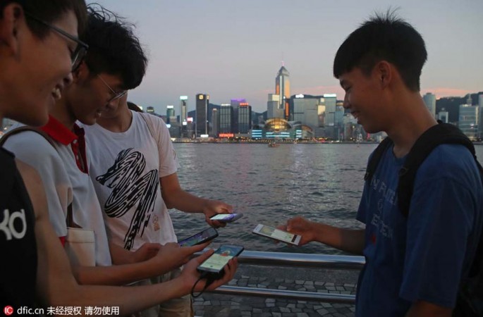 Fans maneuver their smartphones as they play Pokemon Go in Hong Kong on Monday. 
