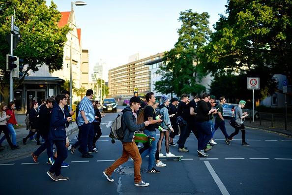 Young players walk through the city centre of Hanover while holding their smartphones and playing 'Pokemon Go.'