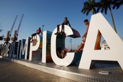 Teens sit on a new sign reading 'Cidade Olimpica' (Olympic City) in the historic port district  in Rio de Janeiro, Brazil. Ahead of the Rio 2016 Olympic Games games.