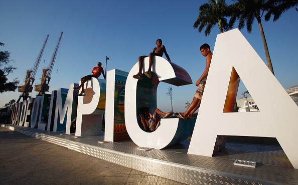 Teens sit on a new sign reading 'Cidade Olimpica' (Olympic City) in the historic port district  in Rio de Janeiro, Brazil. Ahead of the Rio 2016 Olympic Games games.