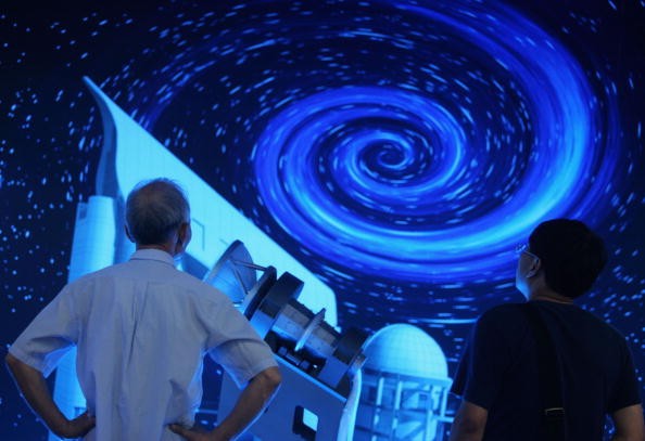 Visitors view a model of the large sky area multi-object fiber spectroscopic telescope (LAMOST) at the Shenzhen Convention & Exhibition Center on Oct. 13, 2006.