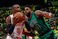 Atlanta Hawks power forward Paul Millsap (L) drives against the Boston Celtics' Amir Johnson.