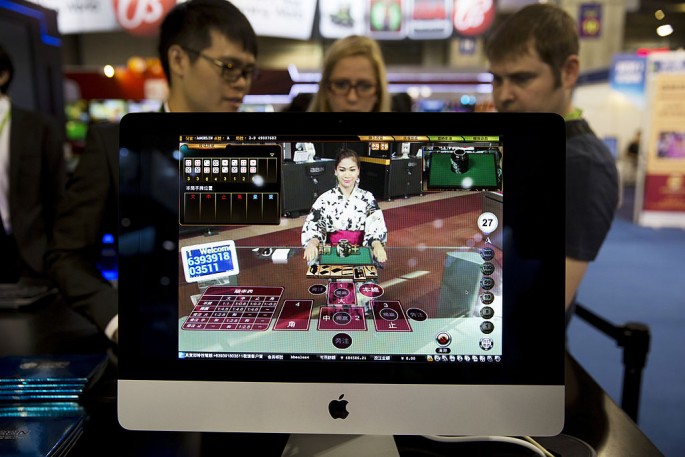 An expo participant explains how online casino is played at the Global Gaming Expo in Macau in 2014.  