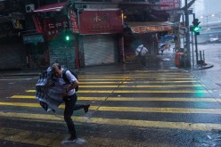 People struggle to control their umbrellas in high winds caused by Typhoon Nida on Aug. 2, 2016 in Hong Kong.