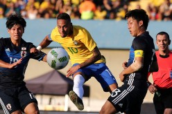 Brazil forward Neymar (middle) goes against two Japanese defenders in a recent friendly match.