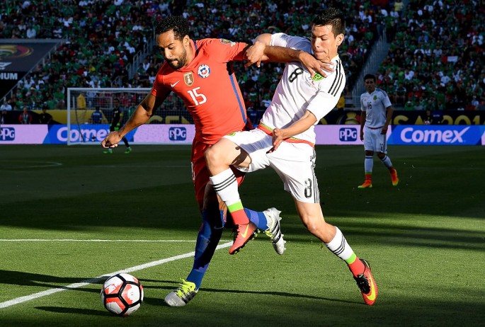 Mexico striker Hirving Lozano (R) competes for the ball against Chile's Jean Beausejour.