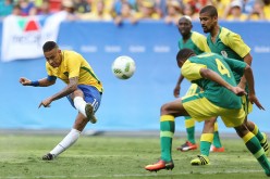 Brazilian winger Neymar (L) shoots the ball against three South African defenders.