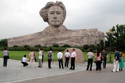 Face-to-face: Tourists gather near the bust of a young Mao Zedong and his wind-blown hair in Orange Isle in Changsha, Hunan Province. The isle loses its 5A tourist attraction rating this month.