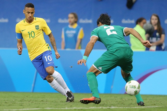 Brazilian forward Neymar (L) shoots the ball against an Iraqi defender.