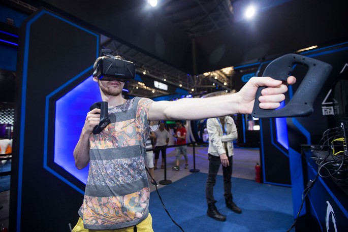 A visitor tries a virtual reality (VR) gadget at Alibaba's Taobao Maker Festival at the Shanghai World Expo Exhibition & Convention Center on July 21, 2016, in Shanghai.